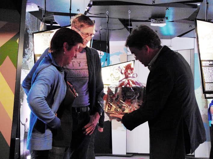 Directeur Wiel Lenders overhandigt de gelukkige bezoekers uit de gemeente Ede een cadeau.